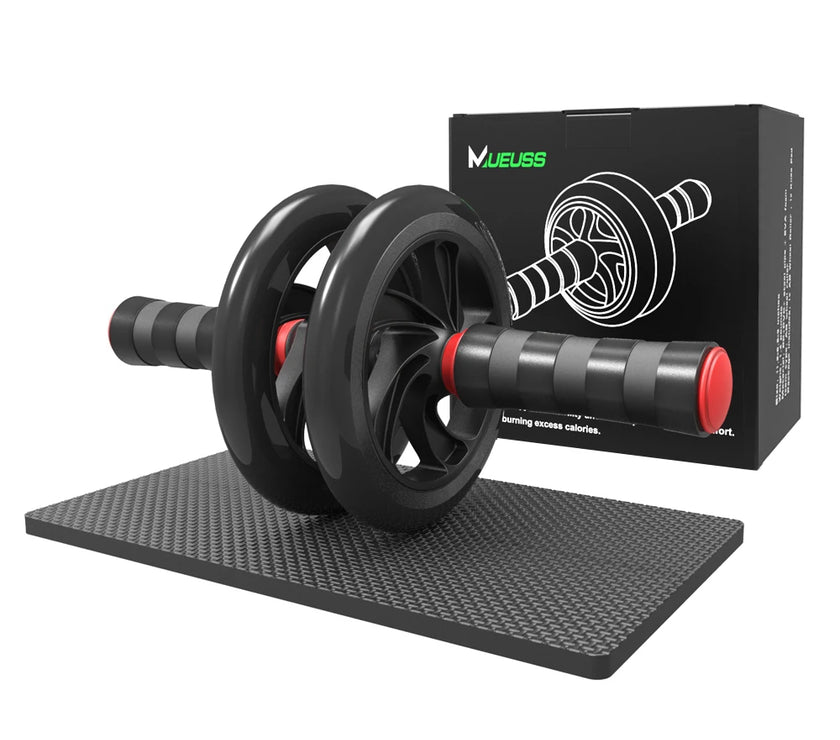 Black ab roller with red accents on a black mat, next to its packaging box.