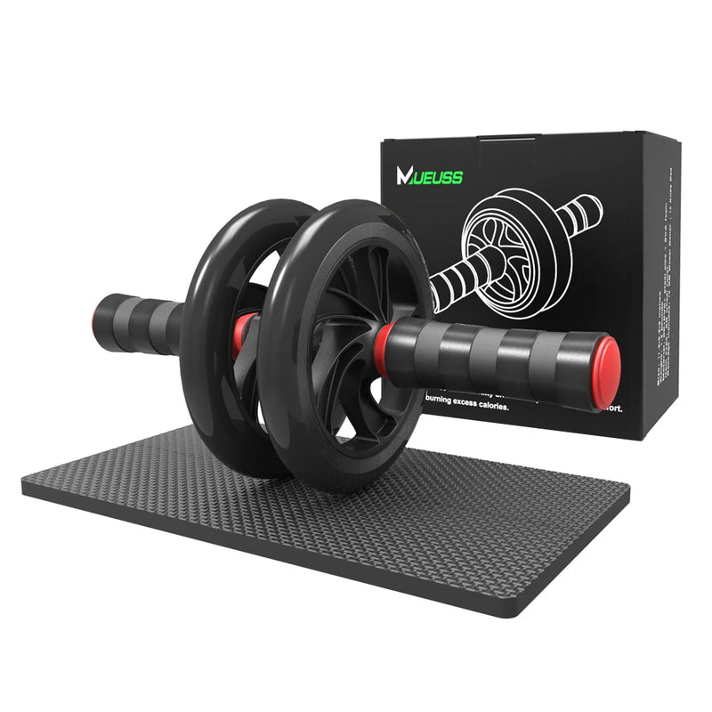 Black ab roller with red accents on a black mat, next to its packaging box.