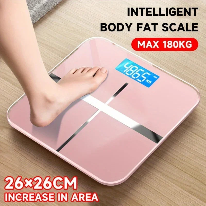 Pink intelligent body fat scale with digital display on a wooden floor.