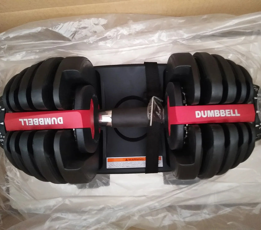Pair of adjustable dumbbells on a clear plastic sheet