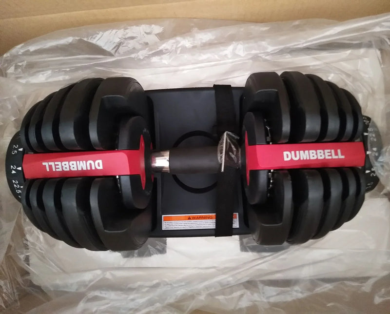 Pair of adjustable dumbbells on a clear plastic sheet