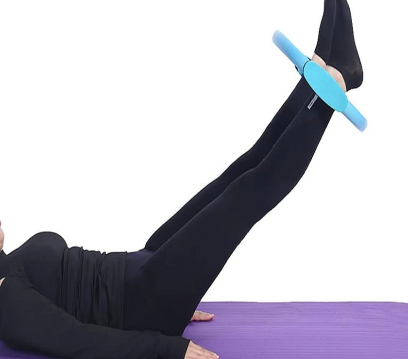 Person using a blue foam roller on a purple mat with a white background
