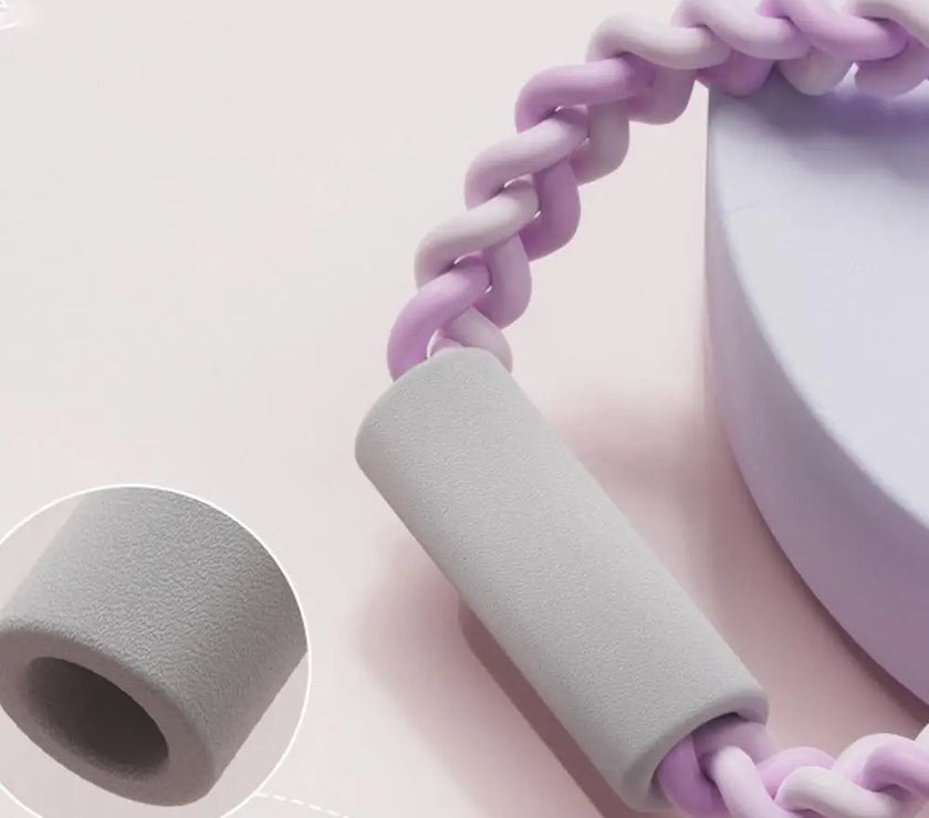 Handheld device with gray handle and pink braided cord on a light pink background