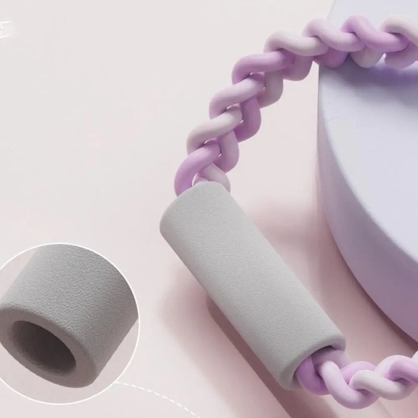 Handheld device with gray handle and pink braided cord on a light pink background