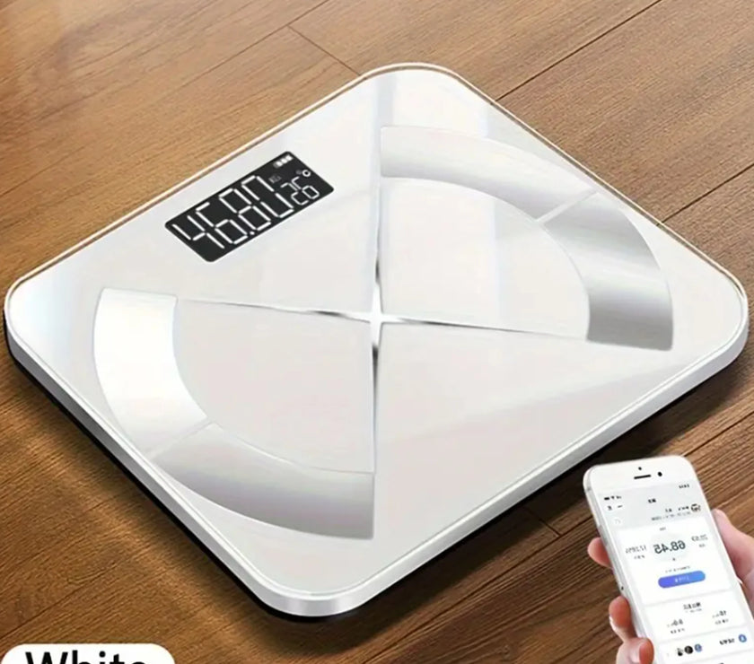 White digital bathroom scale on a wooden floor with a smartphone displaying app.