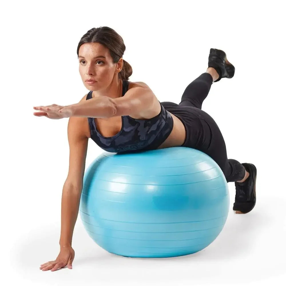 Woman exercising on a blue fitness ball against a white background