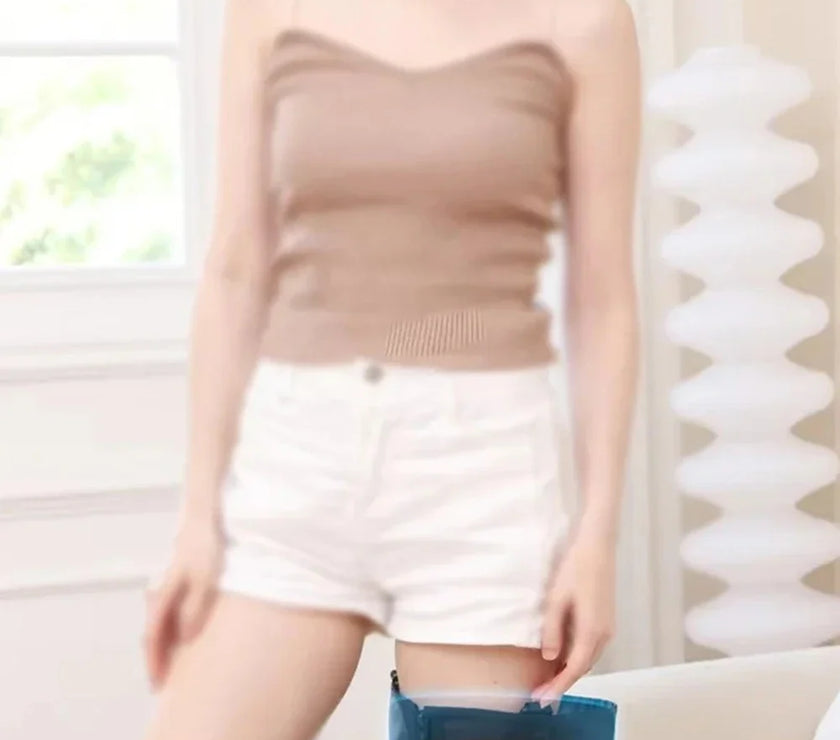 Woman wearing a blue airbag leg support in a room with white walls and a couch.