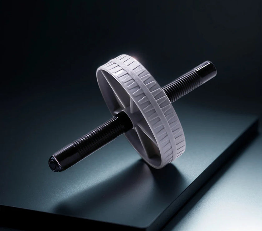 White ab roller on a reflective black surface with a dark background