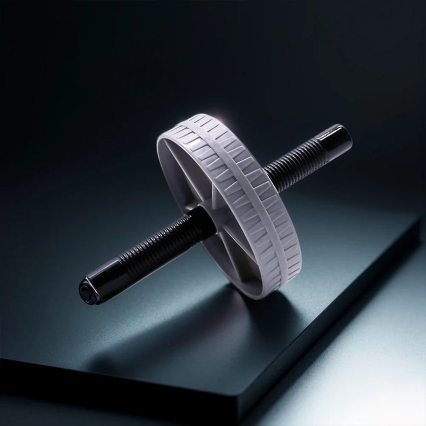 White ab roller on a reflective black surface with a dark background