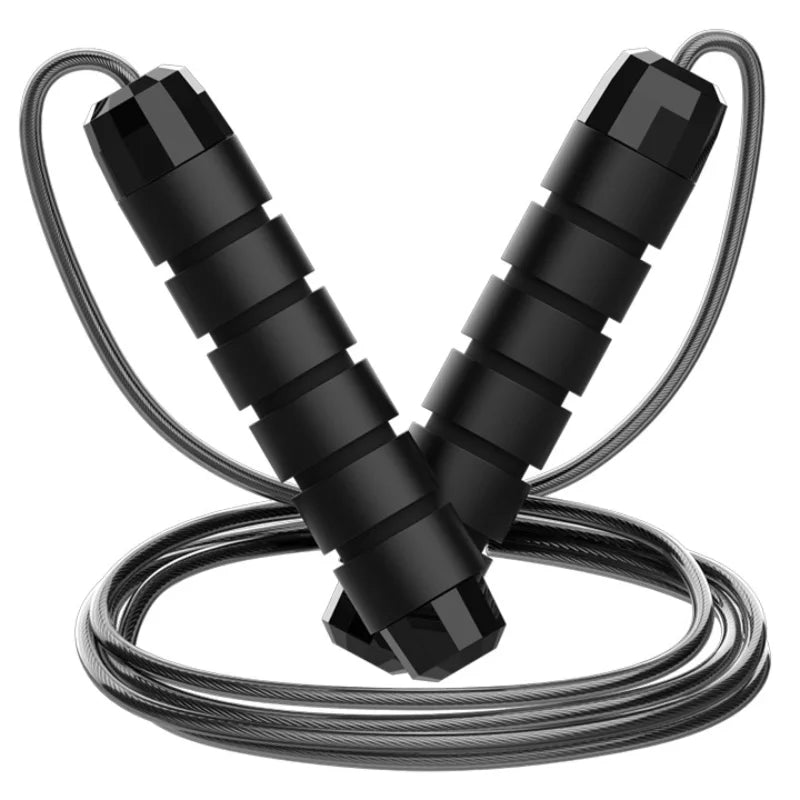 An adjustable jump rope with steel wire and black and red handles lying on a reflective surface.