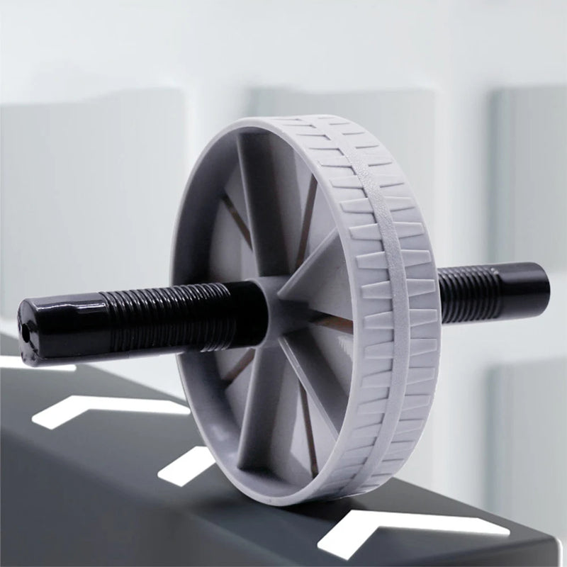 Gray exercise wheel with black handles on a reflective surface