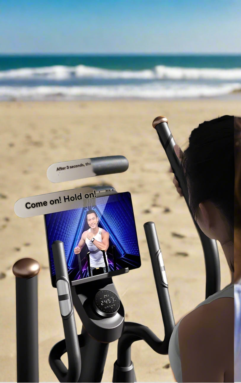 Person using an elliptical machine with a tablet displaying a workout video on a wooden floor.