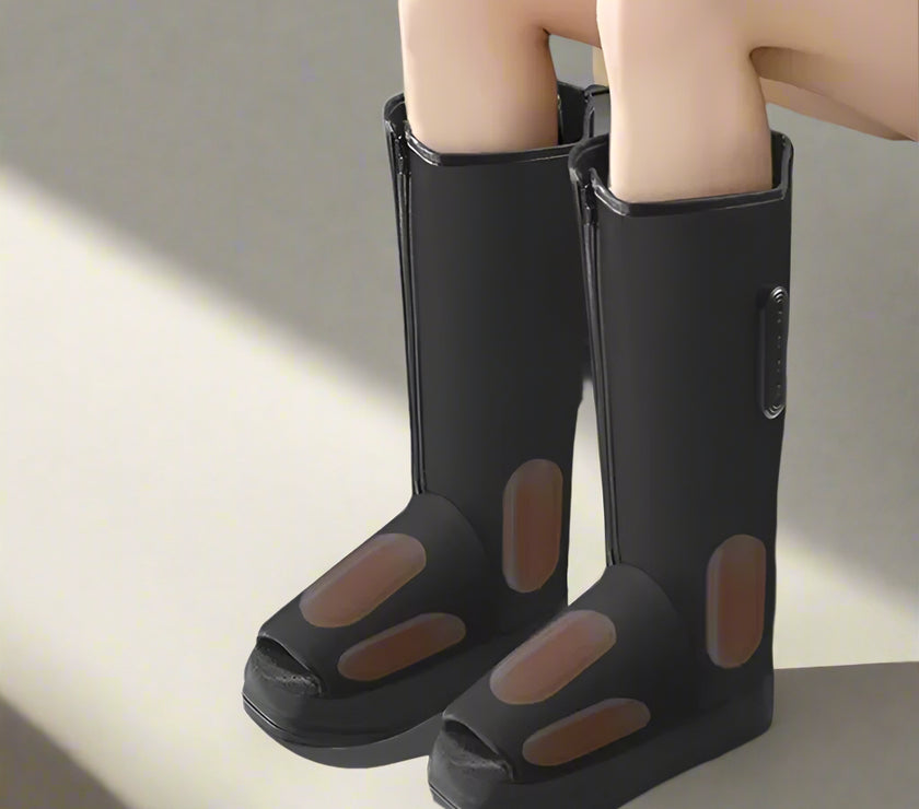 Black rubber boots with open-toe design worn by a person sitting on a couch.