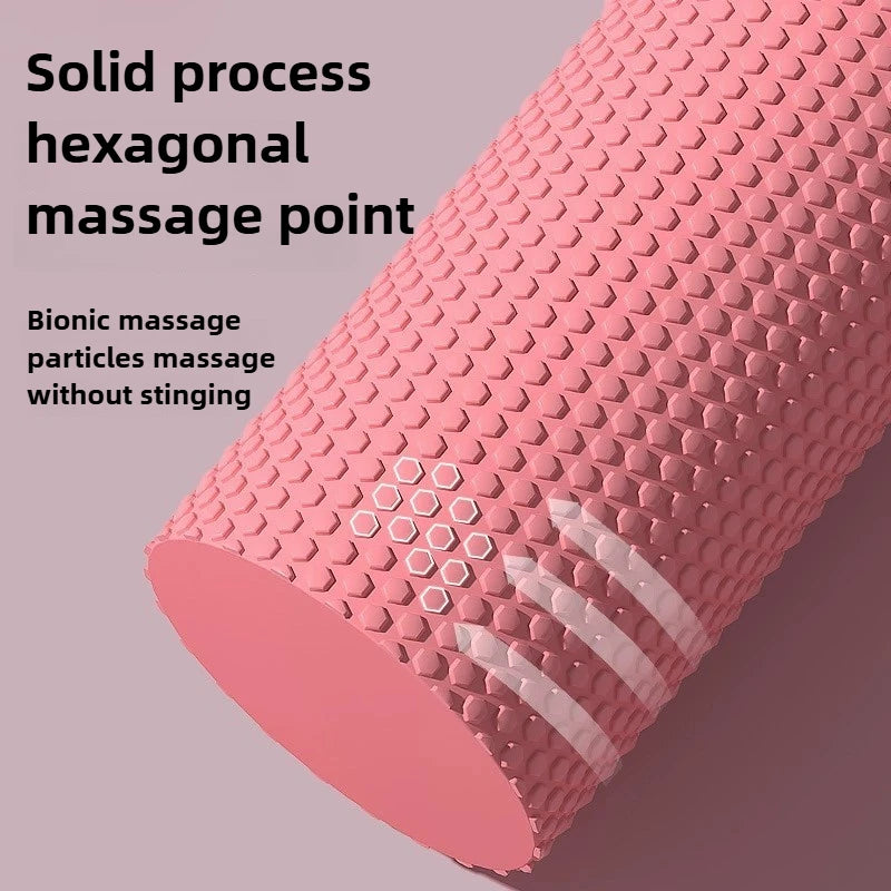 Pink foam roller with hexagonal massage points on a pink background