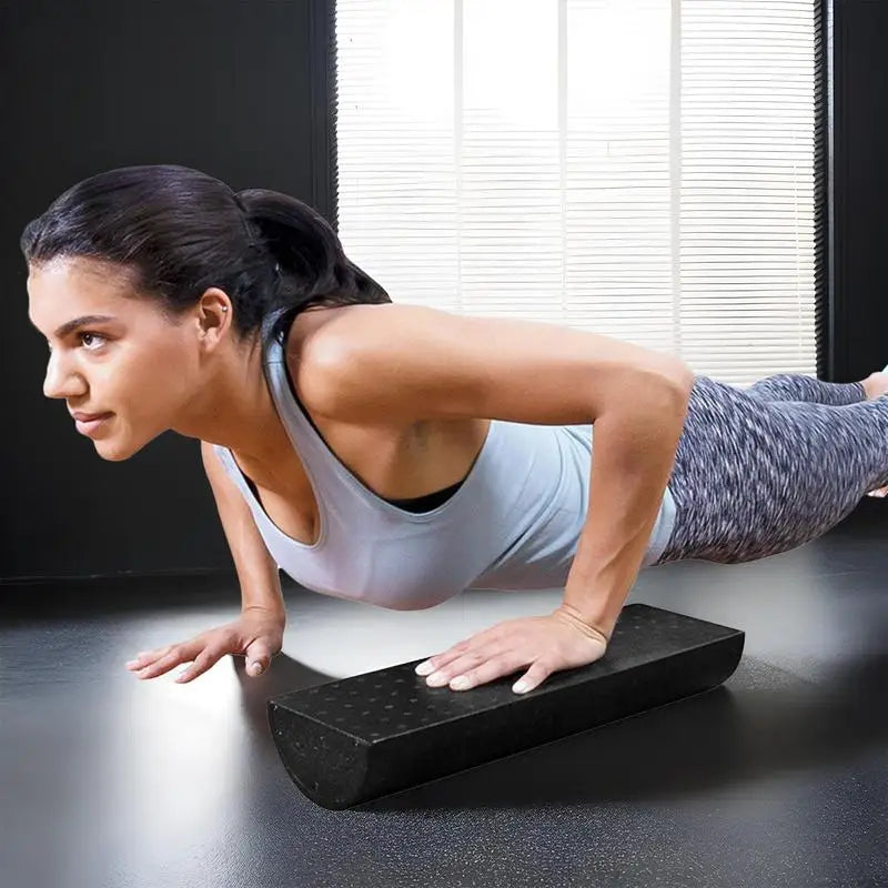 Woman performing push-ups on a black foam roller in a home setting.