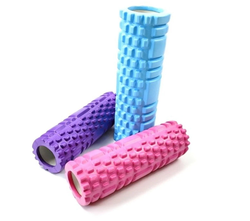 Three foam rollers in purple, blue, and pink on a white background