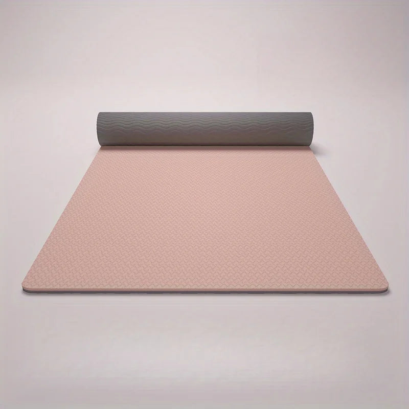 Pink yoga mat with gray rolled-up end on a light gray background