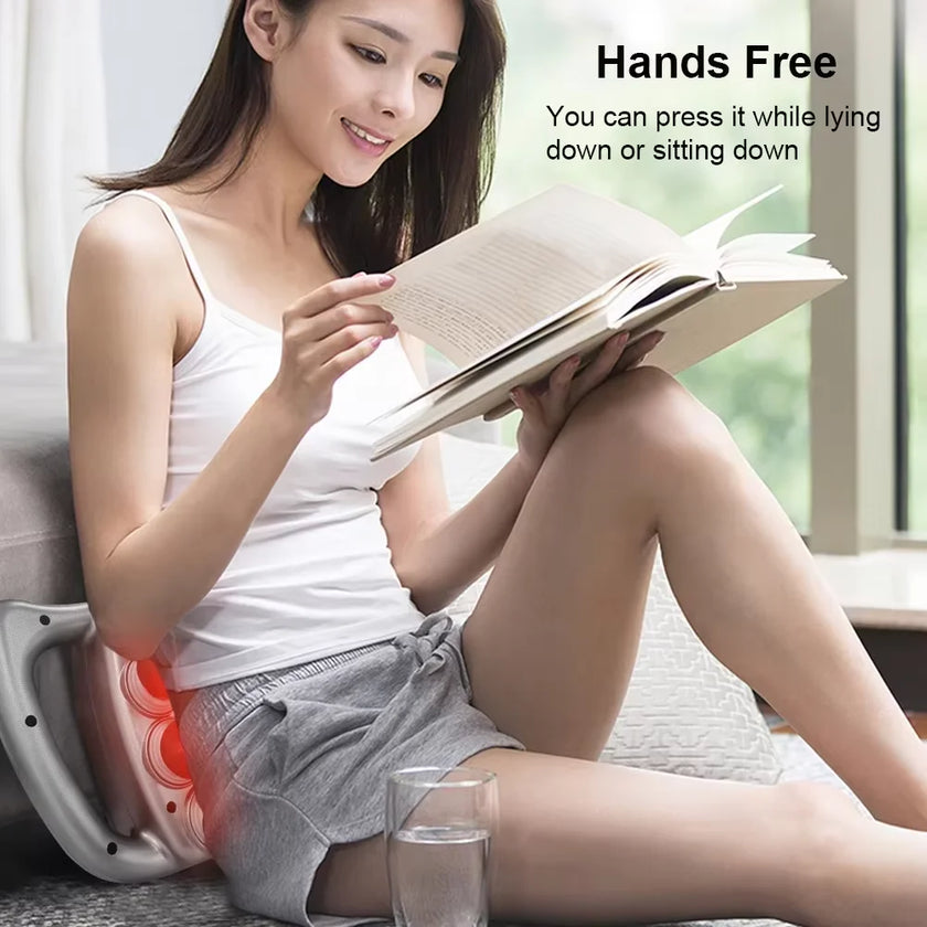 Woman reading a book with a device on her lap, sitting on a couch.