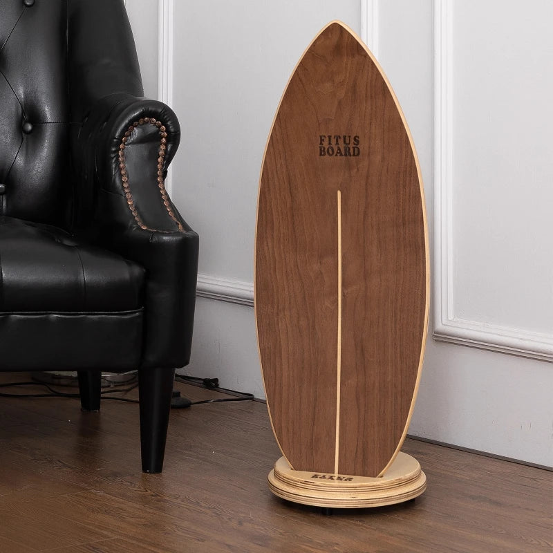 Wooden surfboard on a stand next to a black leather chair indoors.