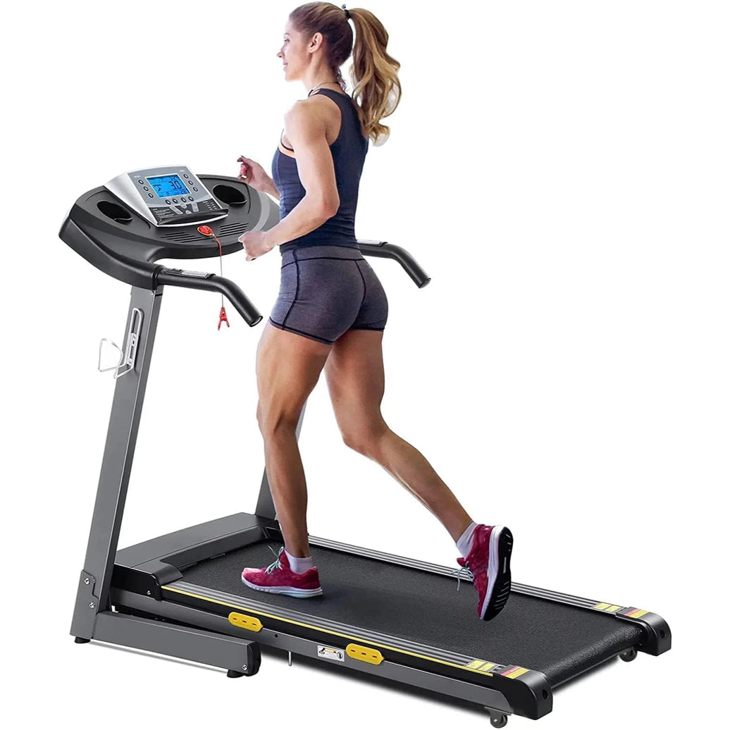 A person is running on a treadmill with a digital display and heart rate sensors.