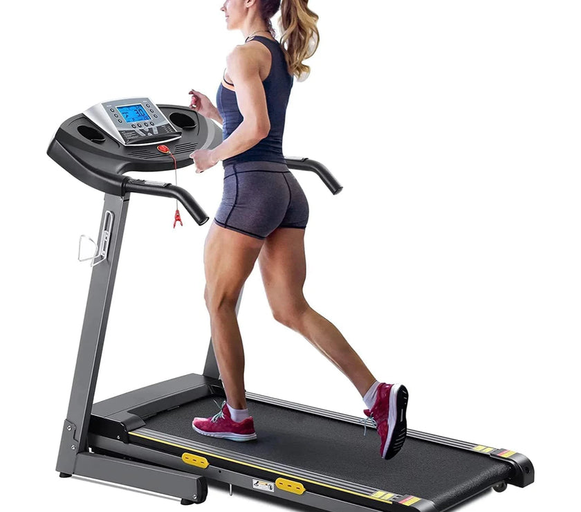 A person is running on a treadmill with a digital display and heart rate sensors.