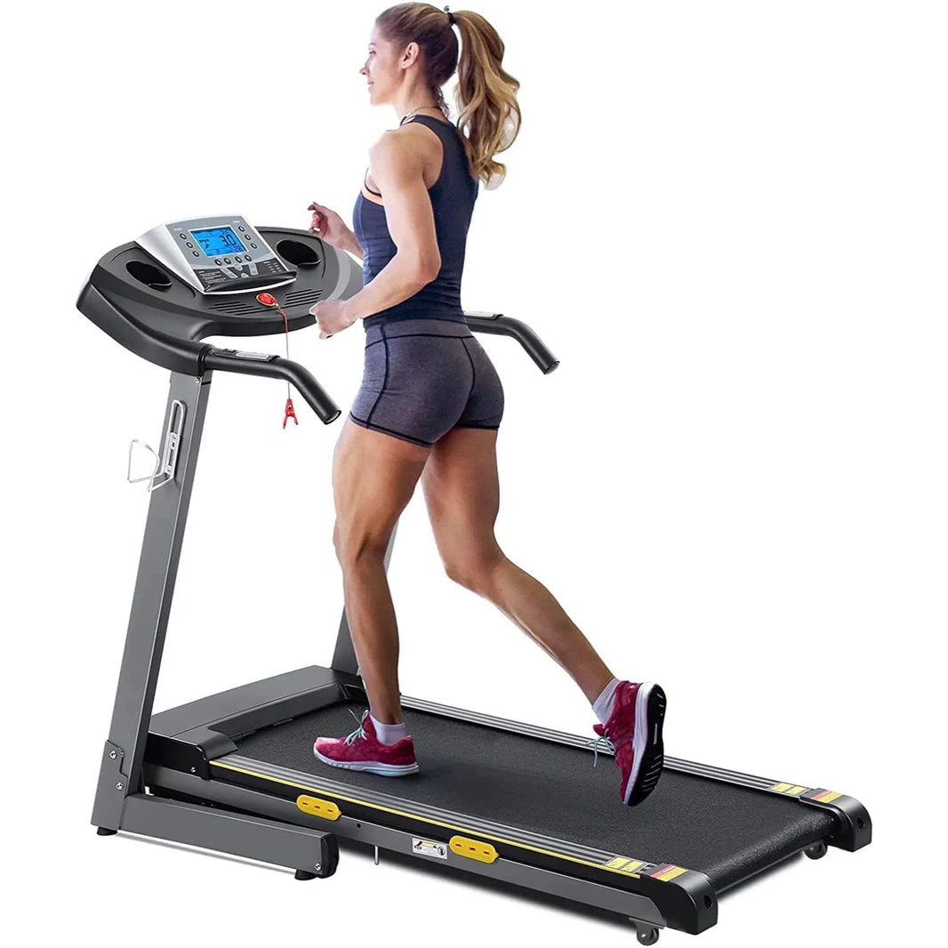 A person is running on a treadmill with a digital display and heart rate sensors.