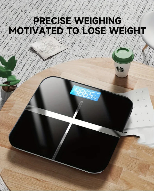 Digital bathroom scale on a wooden table with a Starbucks cup and plant in the background.