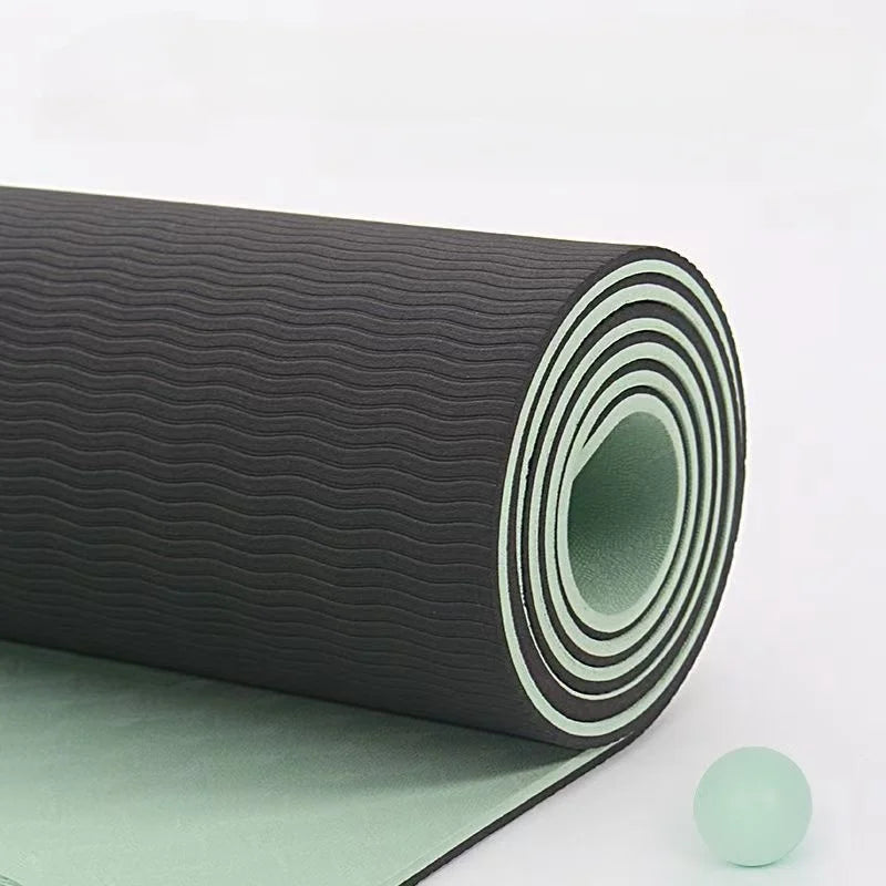 Roll of green and black rubber matting with a small green ball on a light gray background